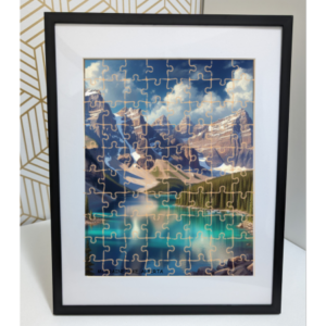 A jigsaw wood puzzle of Moraine Lake in Alberta, featuring vibrant turquoise waters surrounded by towering snow-capped mountains and lush greenery, encased in a sleek black frame.